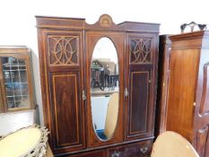 An Edwardian double wardrobe with centre oval mirr
