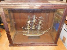 A small model ship with a glazed wooden case