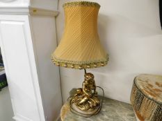 A decorative gilt lamp with shade