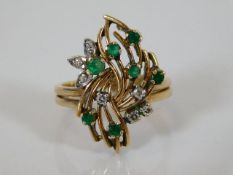 A yellow metal diamond & green stone ring