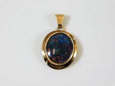 An antique yellow metal black opal pendant
