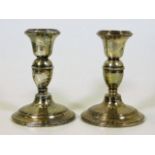 A pair of silver candlesticks, one repaired