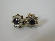 A pair of 9ct earrings set with sapphire & white s