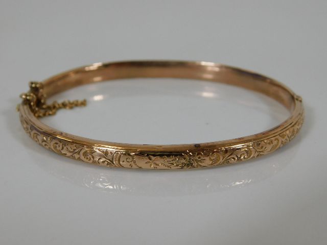 A 9ct gold bangle with chased decor