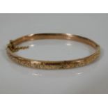 A 9ct gold bangle with chased decor