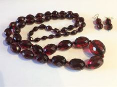 A faceted red amber necklace with yellow metal mou