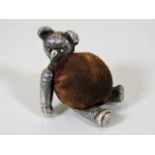 A heavy gauge c.1900 white metal bear pin cushion