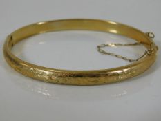 A 9ct gold bangle with chased decor