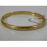 A 9ct gold bangle with chased decor