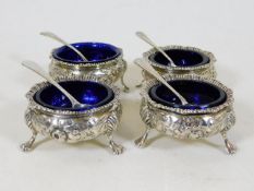A matching set of four silver salts with blue glas