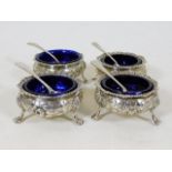 A matching set of four silver salts with blue glas