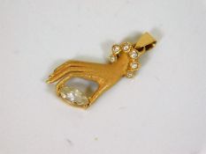 A yellow metal hand pendant
