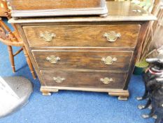 An oak chest of drawers with bracket feet & brass