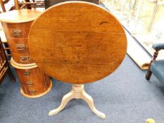 An early 19thC. oak tilt top table with painted pe