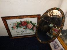 A decoratively framed mirror twinned with religiou