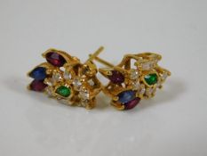 A pair of 21ct gold earrings set with emerald, rub