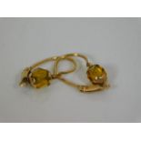 A pair of yellow metal earrings set with citrine