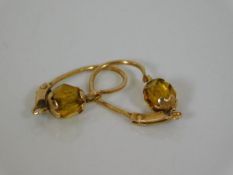 A pair of yellow metal earrings set with citrine