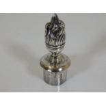 An ornate silver candle snuffer with flame finial