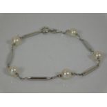 A white metal bracelet set with cultured pearls