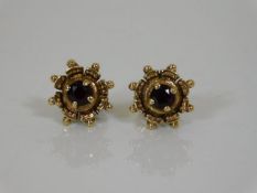 A pair of yellow metal earrings set with garnet