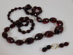 A set of faceted red amber beads & matching earrin