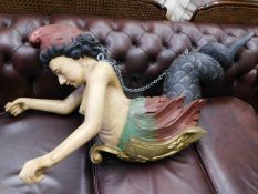 A large carved mermaid figure dated to chest 1877