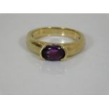 A yellow metal ring set with amethyst