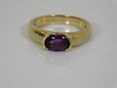 A yellow metal ring set with amethyst