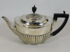 A silver teapot with gadrooned sides