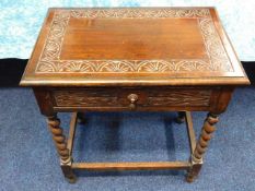 An antique carved oak side table with barley twist