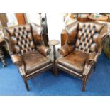 A pair of brown leather chesterfield wingback chai