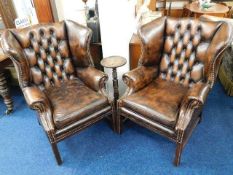 A pair of brown leather chesterfield wingback chai