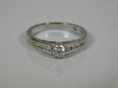An 18ct gold ring set with centre diamond braced b