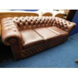 A brown leather chesterfield sofa