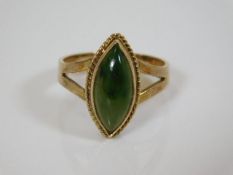 A yellow metal ring set with green stone
