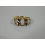 A 9ct gold ring set with three opals & four rubies