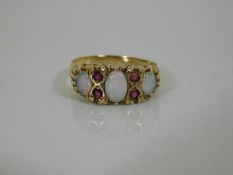 A 9ct gold ring set with three opals & four rubies