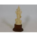 A c.1900 Oriental ivory deity on wooden plinth sta