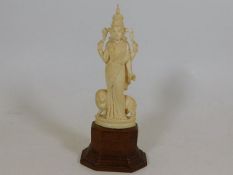 A c.1900 Oriental ivory deity on wooden plinth sta
