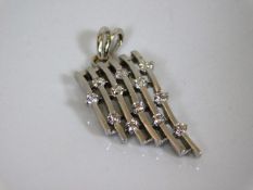 An 18ct white gold & diamond pendant in form of mu