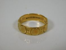 An 18ct gold patterned wedding band
