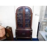 A mahogany art deco bookcase with cupboard under