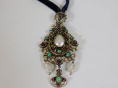 An antique Asian pendant set with ruby, garnet & t