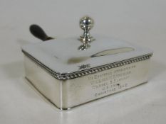 A silver cigar ash box with inscription relating t