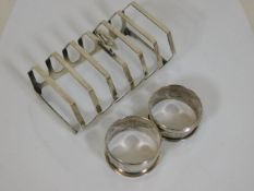 A silver toast rack twinned with a pair of silver
