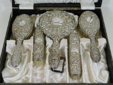 A cased silver backed dressing table set