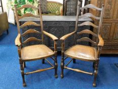 A pair of oak ladderback chairs with studded leath