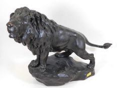 An early 20thC. bronze lion standing on rocky plin