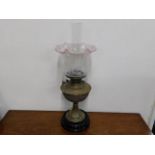 A Victorian brass oil lamp with cranberry tipped v